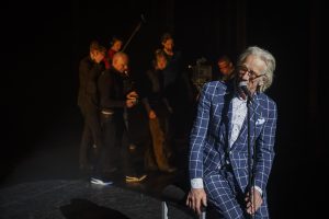 Foto: Regisseur Dennis Alink (met hand voor het hoofd), geluidsman Sander den Broeder, focus-puller Danny van Deventer, DoP Thomas van der Gronde, gaffer Zen Bloot en steadicamoperator Jorrit Haas cirkelen om theatermaker Freek de Jonge. Buiten beeld speelt Nits De muur.